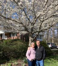 Chris and Myke in front of a tree blooming with white flowers